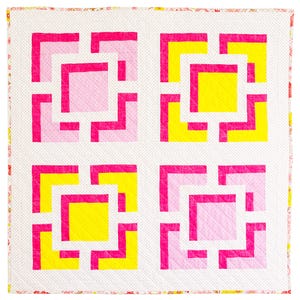 May include: A square quilt with a white background featuring four geometric blocks. Each block has a square center in either pink or yellow, outlined with a bright pink border. The quilt's edge has a floral pattern.