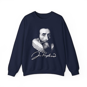 Puede incluir: Sudadera azul marino con un retrato en blanco y negro de un hombre con barba y cuello con volantes. El retrato va acompañado de una firma blanca. La sudadera es de cuello redondo.