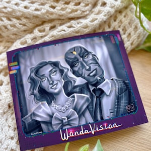 May include: A square print featuring a grayscale illustration of two characters from WandaVision. The woman wears a dress with a large bow and a necklace. The man is in a suit and tie. The print has a purple border with the show's title.