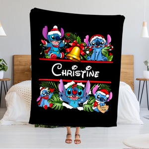 May include: Black blanket featuring Stitch characters in Santa hats and festive decorations. The blanket has the name "Christine" in white script. Stitch is depicted in various poses, holding candy canes and Christmas lights.