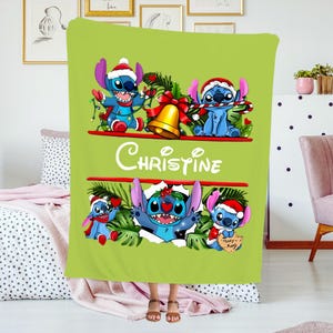 May include: A lime green blanket featuring the character Stitch from Lilo & Stitch in a Christmas theme. The blanket has the name "Christine" in white script. Stitch is wearing a Santa hat and holding candy canes.