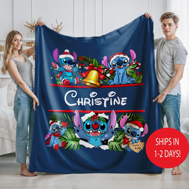May include: A navy blue blanket with Stitch characters in Santa hats and festive decorations. The blanket displays the name "Christine" in white script. A red circle with white text reads "SHIPS IN 1-2 DAYS!"