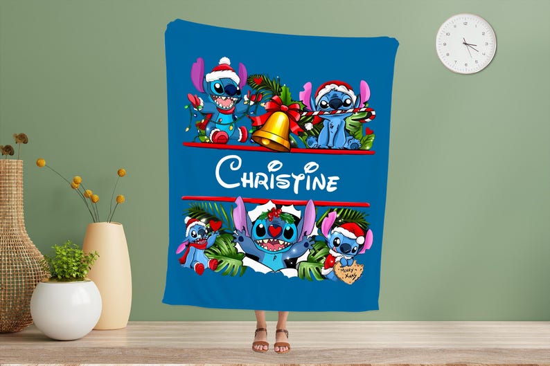 May include: A blue blanket with a Christmas-themed design featuring Stitch from Lilo & Stitch. The blanket has the name "Christine" and Stitch is wearing a Santa hat and holding festive decorations. A seasonal, festive blanket.