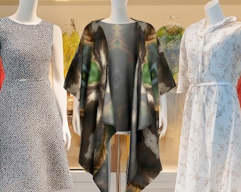 May include: A brown and black animal print shawl with a green and brown design. The shawl is draped over a mannequin in a retail store setting.