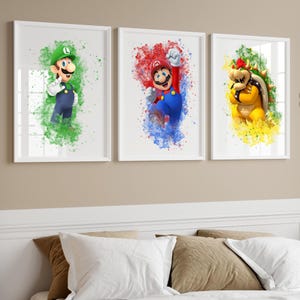 May include: Three framed art prints with watercolour-style illustrations of video game characters. The prints show Luigi in green, Mario in red and blue, and Bowser in yellow and green, each against a splash of colour.