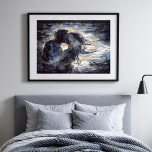 Op de afbeelding: Een ingelijste kunstdruk met een abstract schilderij van twee figuren in een nauwe omhelzing. Het kunstwerk gebruikt een kleurenpalet van donker marineblauw en zwart met contrasterende gouden verfstreken en accenten voor beweging.