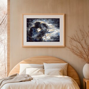 Op de afbeelding: Een ingelijste rechthoekige wandkunstprint met een abstract schilderij van twee figuren in een nauwe omhelzing. Het kunstwerk gebruikt diepe marineblauwe, zwarte en witte tinten met metallic gouden accenten die rond de silhouetten van de figuren wervelen.
