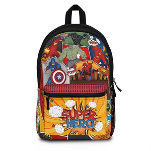 May include: Black backpack featuring a colorful comic book-style design with superhero characters. The front pocket has the words "SUPER HERO" in a yellow burst. The backpack has a black handle and zipper.