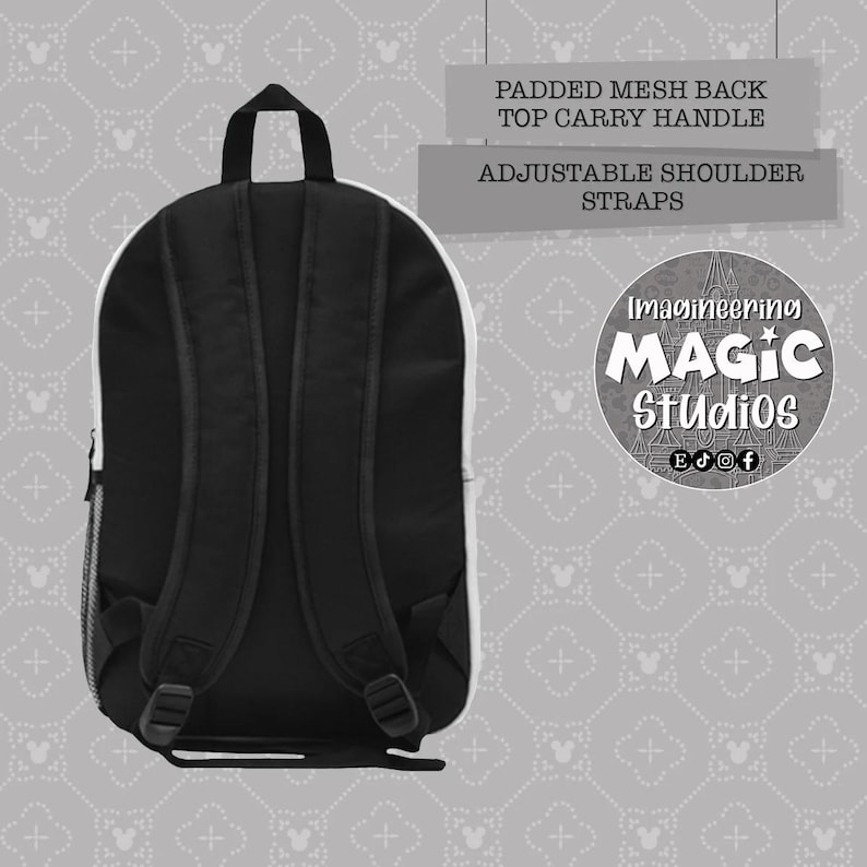 Puede incluir: Mochila negra con respaldo de malla acolchado, asa de transporte superior y correas de hombro ajustables. La mochila tiene un borde blanco y un fondo blanco con un patr&oacute;n gris de cabezas de Mickey Mouse y signos m&aacute;s. El texto "Imagineering Magic Studios" est&aacute; impreso en la mochila en un c&iacute;rculo blanco con un contorno negro.