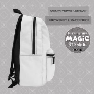 Puede incluir: Una mochila blanca con correas negras y un bolsillo con cremallera. La mochila est&aacute; hecha de 100% poli&eacute;ster y es ligera e impermeable. El texto "Imagineering Magic Studios" est&aacute; impreso en la mochila.