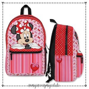 May include: A red and pink backpack featuring a Minnie Mouse design. The backpack has a large front pocket with a zip and a smaller pocket on the side. The Minnie Mouse design includes a red bow and white polka dots.