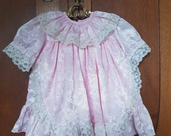 Robe smockée bébé rose des années 1980 en satin avec volants, dentelle et col blancs | Club bébé C&A