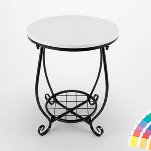 May include: A small, round side table with a white tabletop and a black metal frame. The table has a decorative, scrolled base and a lower shelf. The table is approximately 20 inches in diameter and 24 inches tall.