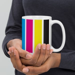 May include: A white ceramic mug with a handle. The mug has a design of four vertical stripes in cyan, magenta, yellow, and black.