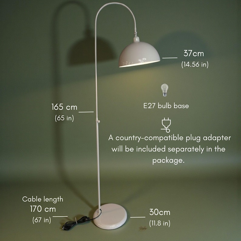 Może przedstawiać: Biała lampa podłogowa z zakrzywionym ramieniem i kloszem w kształcie kopuły. Lampa ma 165 cm wysokości, z kloszem o średnicy 37 cm i kablem o długości 170 cm. Podstawa ma średnicę 30 cm. Używa oprawki żar&oacute;wki E27.