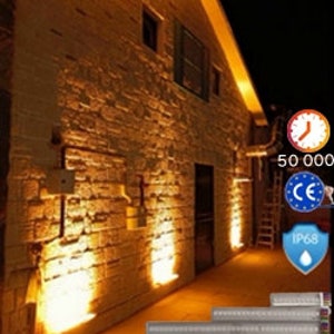Puede incluir: Tres luces LED de color blanco cálido iluminan una pared de piedra por la noche. Las luces están montadas en la pared y proyectan un brillo cálido. Las luces son impermeables y tienen una clasificación IP68. Las luces también están certificadas CE y tienen una vida útil de 50.000 horas.