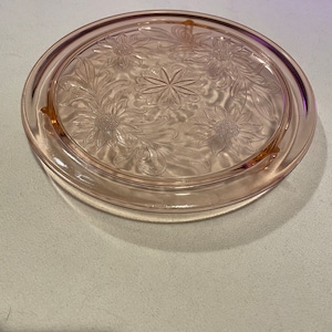 Pink depression glass cake stand with floral pattern
