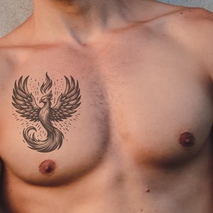 May include: A man with a black and white phoenix tattoo on his chest.