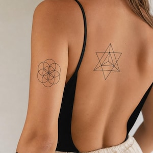 May include: Three black ink temporary tattoos applied to skin. One tattoo on the upper arm features a circular geometric flower pattern. A second tattoo on the back displays a six-pointed star with internal lines. A third tattoo on the forearm shows a repeating horizontal zigzag wave pattern.