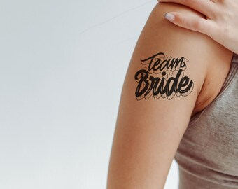 May include: A person's arm with a temporary tattoo that says "Team Bride" in black script.