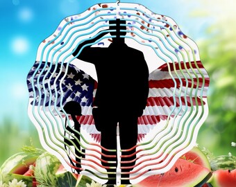 May include: A metal wind spinner with a silhouette of a person saluting in front of an American flag. The spinner has multiple layers of colorful metal, creating a swirling effect.