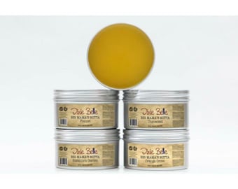 May include: Four silver tins of Dixie Belle Big Mama's Butta body butter, each with a different scent: Paccel, Unscented, Shamrock's Garden, and Orange Grove.
