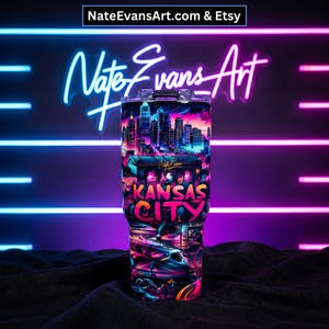 May include: A stainless steel tumbler featuring a vibrant, neon-style design of the Kansas City skyline and cityscape. The tumbler has a black lid and is decorated with the words "Kansas City" in bright pink and orange. The background features neon lights.