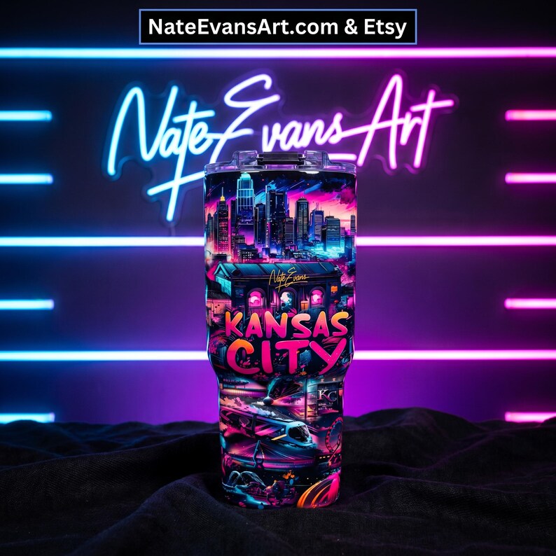 May include: A stainless steel tumbler featuring a vibrant, neon-style design of the Kansas City skyline and cityscape. The tumbler has a black lid and is decorated with the words "Kansas City" in bright pink and orange. The background features neon lights.