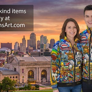 Puede incluir: Una pareja con chaquetas con cremallera coloridas con tem&aacute;tica de Kansas City, de pie frente a un paisaje urbano al atardecer. Las chaquetas presentan varios puntos de referencia de Kansas City y el texto "Kansas City 2026". La imagen incluye el texto "One of a kind items only at NateEvansArt.com".