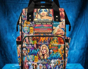 Könnte beinhalten: Ein mehrfarbiger Rucksack mit einer Collage aus Bildern und Text. Der Rucksack hat einen schwarzen oberen Griff und Träger. Auf der Vorderseite des Rucksacks steht der Text "THE FAME", "THE FAME MONSTER", "BORN THIS WAY", "ARTPOP", "CHEEK TO CHEEK", "JOANNE" und "CHROMATICA".