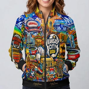 Puede incluir: Chaqueta bomber con cremallera con un dise&ntilde;o colorido con monumentos de la ciudad y el texto "Kansas City 2026". La chaqueta tiene cuello, pu&ntilde;os y dobladillo negros, y el dise&ntilde;o cubre toda la chaqueta.