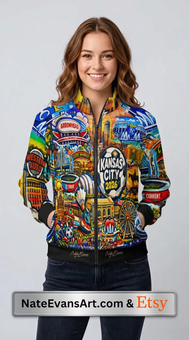 Puede incluir: Chaqueta bomber con cremallera con un dise&ntilde;o colorido con monumentos de la ciudad y el texto "Kansas City 2026". La chaqueta tiene cuello, pu&ntilde;os y dobladillo negros, y el dise&ntilde;o cubre toda la chaqueta.