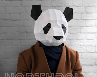 May include: A person wearing a brown jacket and a black scarf with a white and black paper mache panda mask.