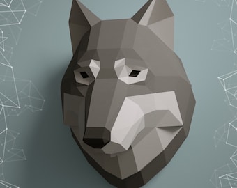 Puede incluir: Una escultura de cabeza de lobo de papel gris con un diseño geométrico. La escultura está montada en una pared azul claro con un patrón geométrico blanco en el fondo. El texto "GURKO DESIGN STUDIO" y "NORTHPOLY" son visibles debajo de la escultura.