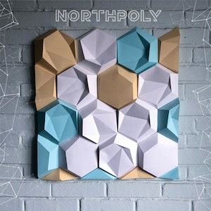 May include: A wall decor piece made of geometric shapes in white, light blue, and gold. The shapes are arranged in a honeycomb pattern.
