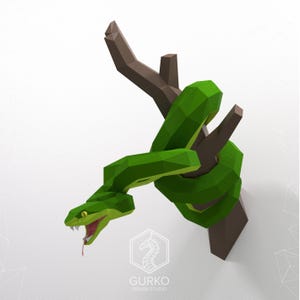 May include: A green snake wrapped around a brown branch, with its head facing forward and its mouth open. The snake is made of paper and is a 3D model.