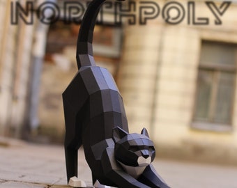 Puede incluir: Modelo de gato de papelcraft negro y blanco en una pose de estiramiento. El gato está hecho de papel doblado y tiene una apariencia realista.