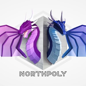May include: Two papercraft dragon heads, one purple and one blue, with wings outstretched, mounted on a white wall. The text "NORTHPOLY" is printed below the dragons.