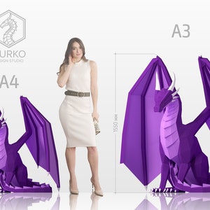 May include: Two purple origami dragon papercraft models in different sizes. The larger dragon is labeled "A3" and measures 15.50 inches tall. The smaller dragon is labeled "A4" and measures 11.00 inches tall. The text "GURKO DESIGN STUDIO" is visible in the top left corner.
