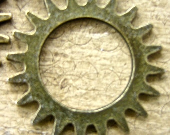 May include: A large, gold-colored gear with a circular opening in the center. The gear has a rough, textured surface and is made of metal.