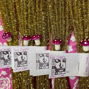 May include: A close-up of four small white and pink mushroom-shaped bottle stoppers. Each stopper has a black and white image of a face with the text "Pink Supply" and "Etsy.com".