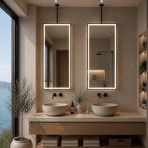 May include: Two rectangular wall-mounted mirrors with integrated LED lighting frames, suspended by black metal rods above a wooden vanity featuring two beige stone vessel sinks, black wall-mounted faucets, and open shelving with folded towels.
