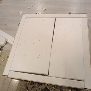 Puede incluir: Una caja de env&iacute;o cuadrada de cart&oacute;n que contiene dos paneles rectangulares de espuma de poliestireno blanca. Las piezas de espuma est&aacute;n dispuestas una al lado de la otra dentro del marco de la caja, con tiras de espuma adicionales.