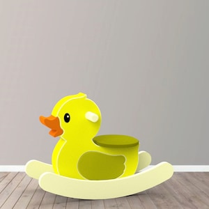 May include: A yellow wooden rocking duck toy with a green seat. The duck has a small orange beak and black eyes.