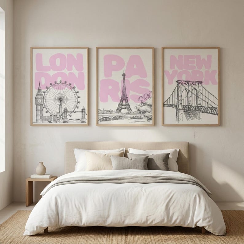 May include: Three framed art prints featuring iconic cityscapes. The prints display the London Eye, Eiffel Tower, and Brooklyn Bridge, each with a pink city name overlay. The artwork is in black and white with a light beige background.