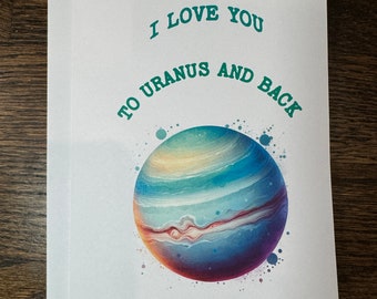 Könnte beinhalten: Eine weiße Karte mit grünem Text, der "Ich liebe dich bis zum Uranus und zurück" lautet. Unter dem Text befindet sich eine farbenfrohe Illustration des Planeten Uranus.