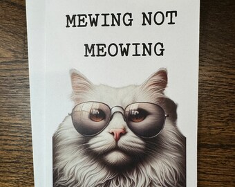 Könnte beinhalten: Eine weiße Katze mit Sonnenbrille, die einen coolen Ausdruck trägt. Der Text "MEWING NOT MEOWING" ist auf der Karte gedruckt.