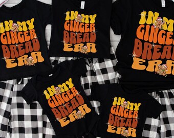 May include: A set of four black t-shirts with the text "In My Gingerbread Era" in a retro font. The shirts are decorated with a gingerbread man graphic. The shirts are available in different sizes for adults and children.