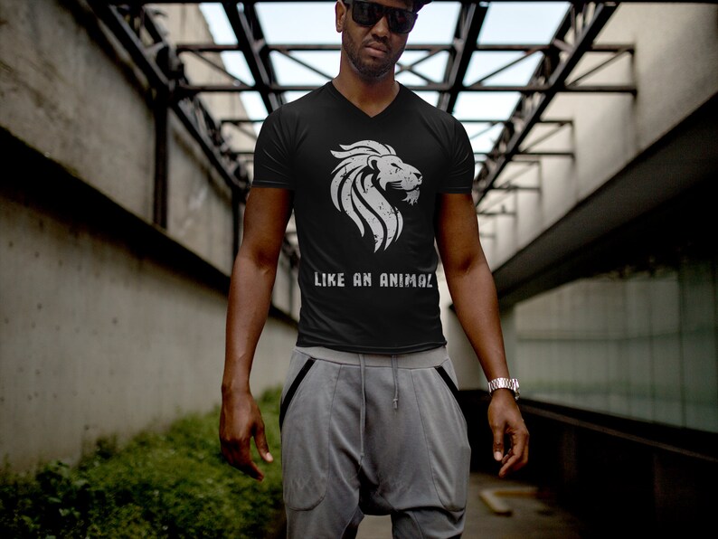 K&ouml;nnte beinhalten: Ein schwarzes V-Ausschnitt-T-Shirt mit einem wei&szlig;en L&ouml;wen-Motiv und dem Text "LIKE AN ANIMAL".