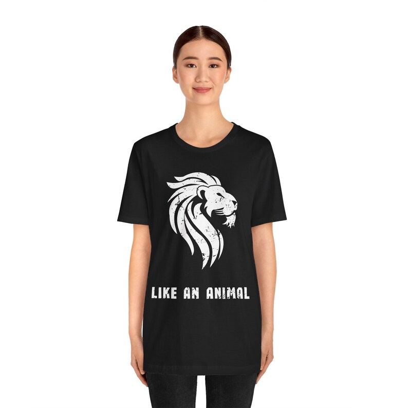 K&ouml;nnte beinhalten: Schwarzes T-Shirt mit einem wei&szlig;en L&ouml;wen-Motiv und dem Text "LIKE AN ANIMAL" in Wei&szlig;.